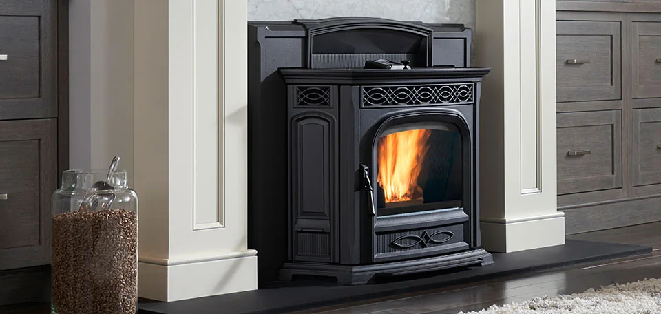 A Harman Accentra52i-TC pellet insert burning in a white masonry fireplace