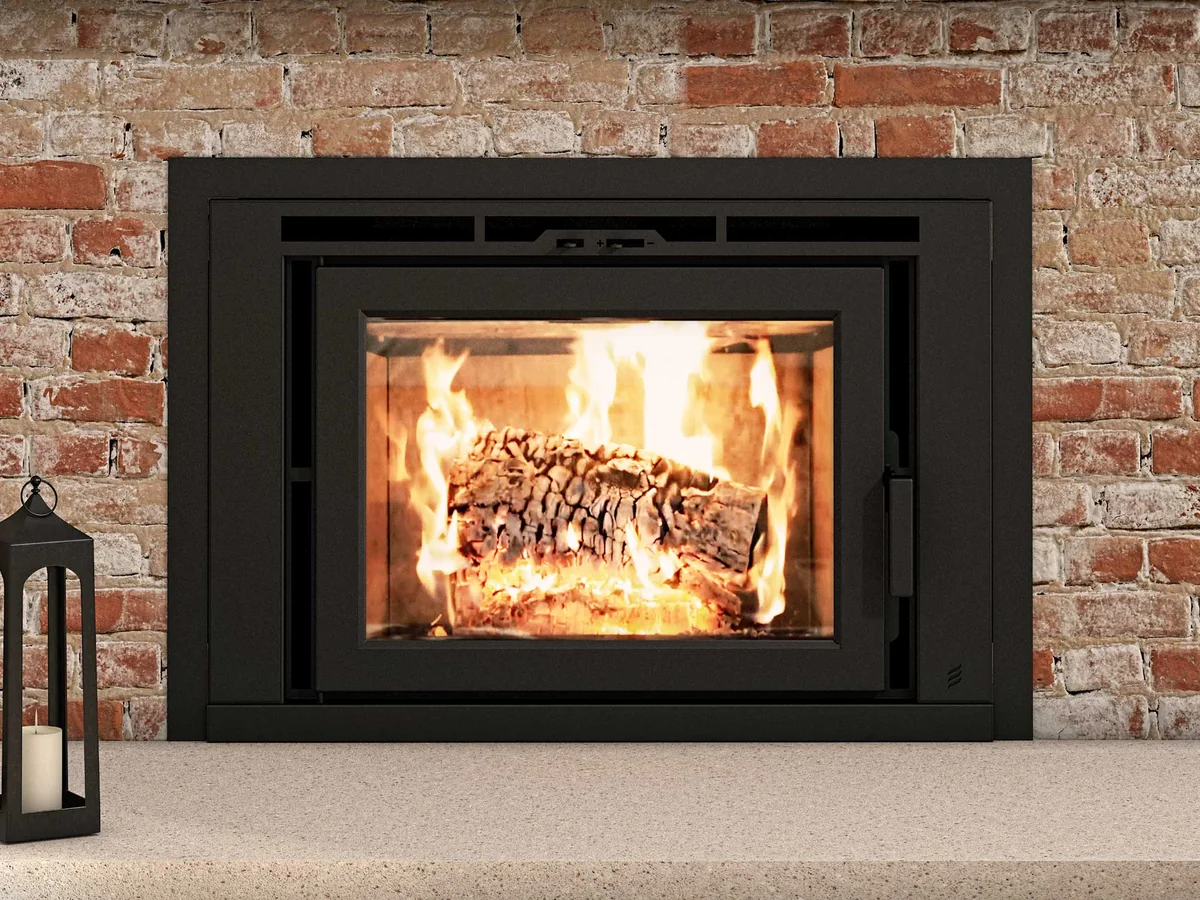 A Supreme Flair 25 wood insert burning in a brick fireplace opening